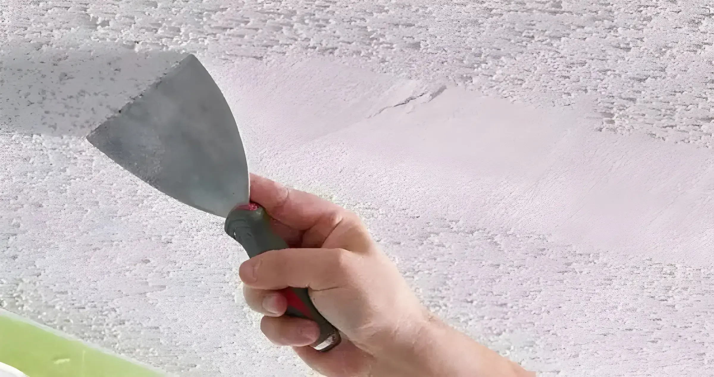 Los Pintores Castellón eliminando el gotelé con espátula para dejar la pared lisa